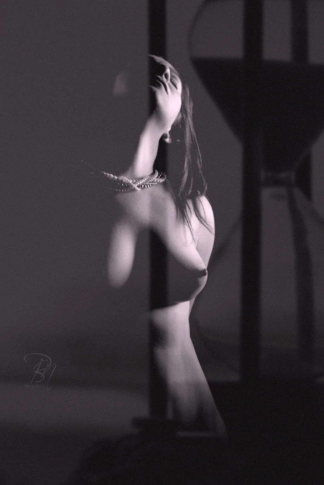 Hourglass — Photo: Norbert Banhalmi A woman stands with her arm raised while an hourglass rises behind her.