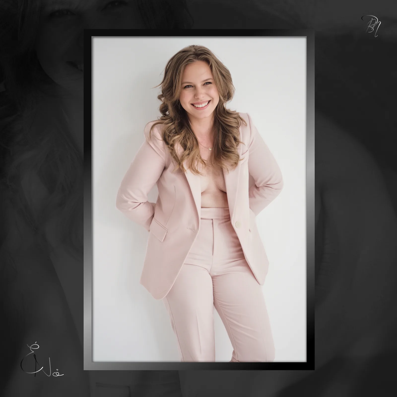 Pink suit — Photo: Norbert Banhalmi A smiling woman in a pale pink suit stands against a plain white wall.