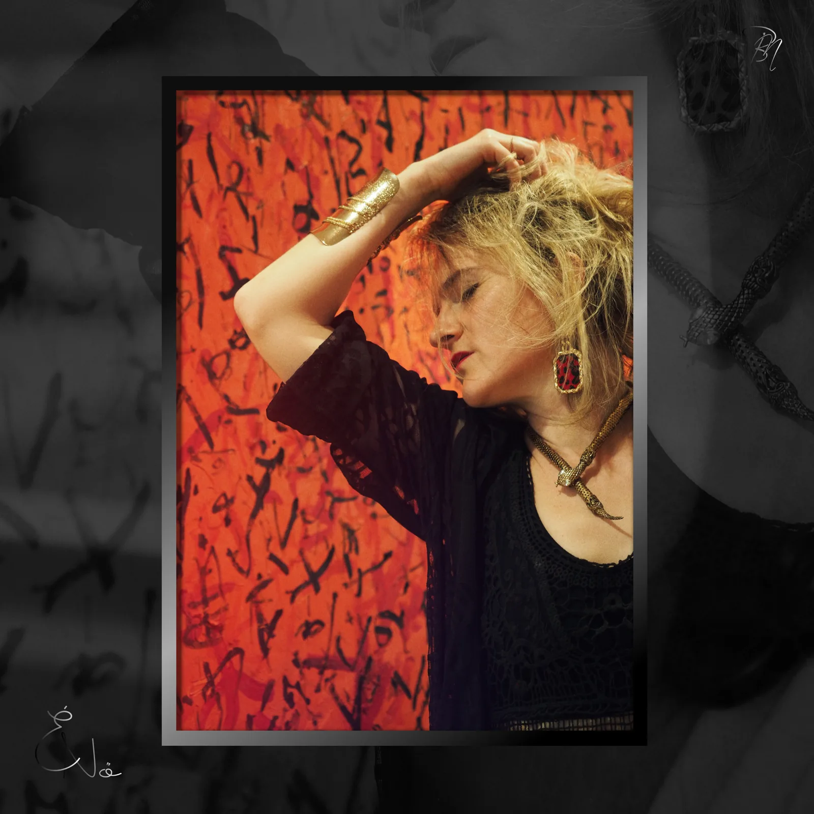 Red wall — Photo: Norbert Banhalmi A woman with her hand in her hair stands against a red painted wall.