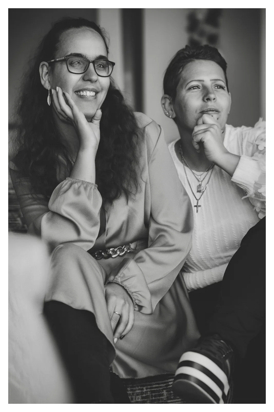 Side by side — Photo: Norbert Banhalmi A woman rests her chin on her hand and smiles; a young person sits beside her.