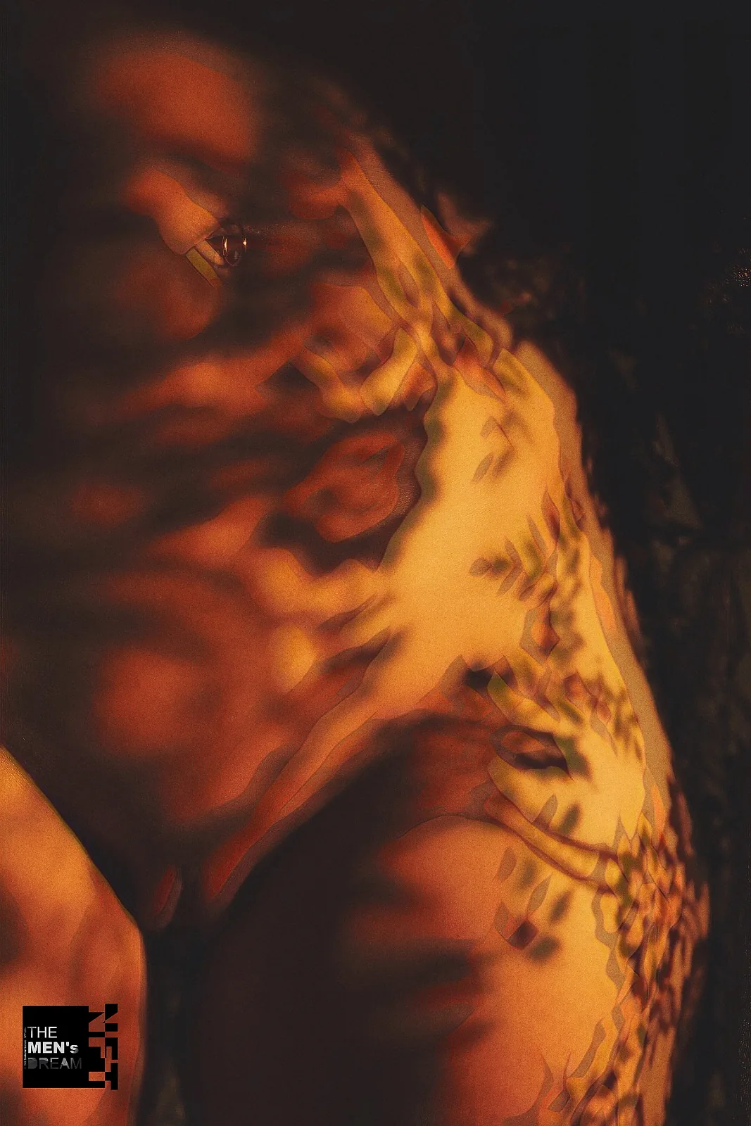 Amber pattern — Photo: Norbert Banhalmi Warm amber light throws a lace pattern across skin in near darkness.