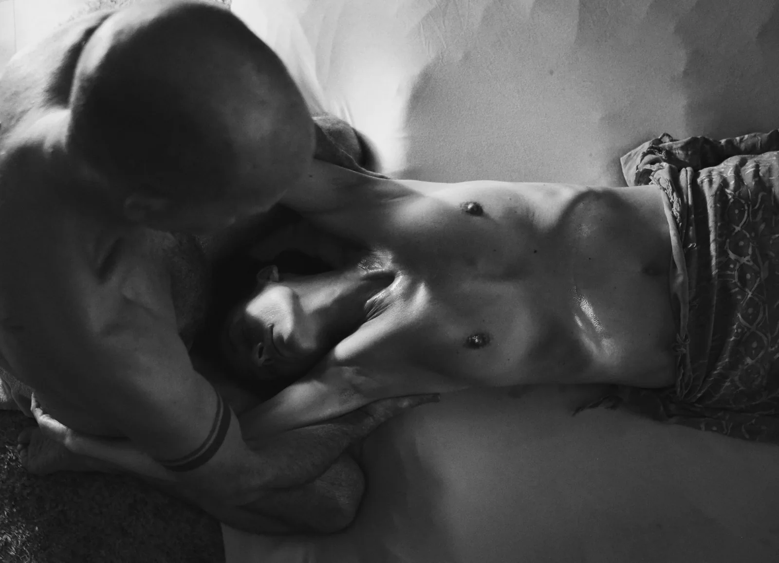Face to face — Photo: Norbert Banhalmi Two people lie close, faces almost touching, one leaning over the other.